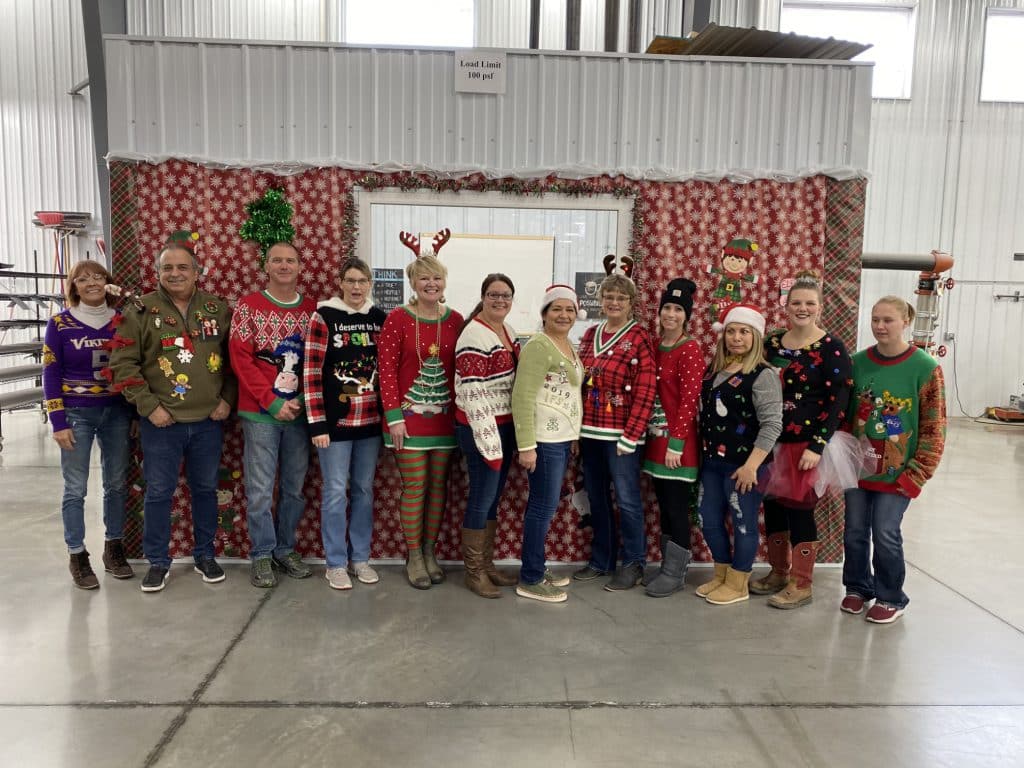 Picture of a dozen IFS employees dressed up in ugly sweaters for Christmas