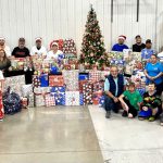 IFS crew posing in front of wrapped presents for Giving & Receiving program